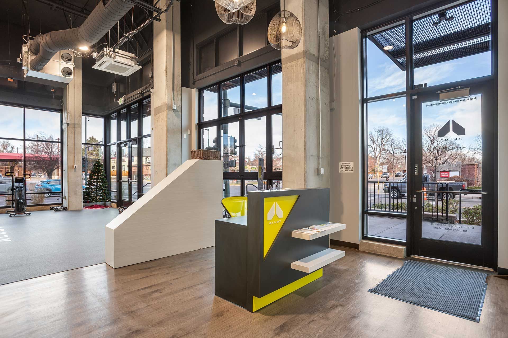 interior view of a modern building entrance with a reception desk, large windows, and an open layout