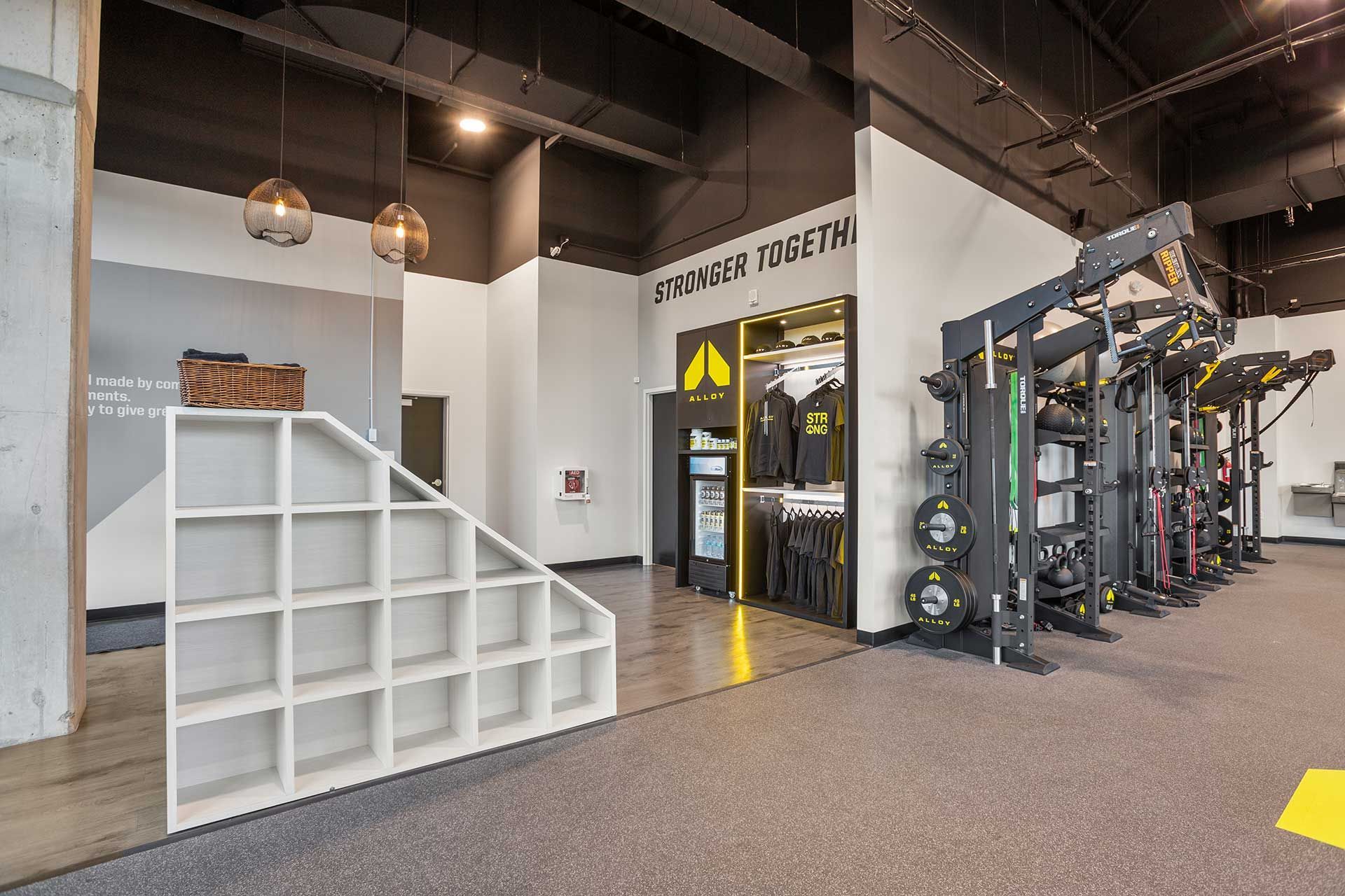 gym interior with exercise equipment, gray and black color scheme, and cubby shelves