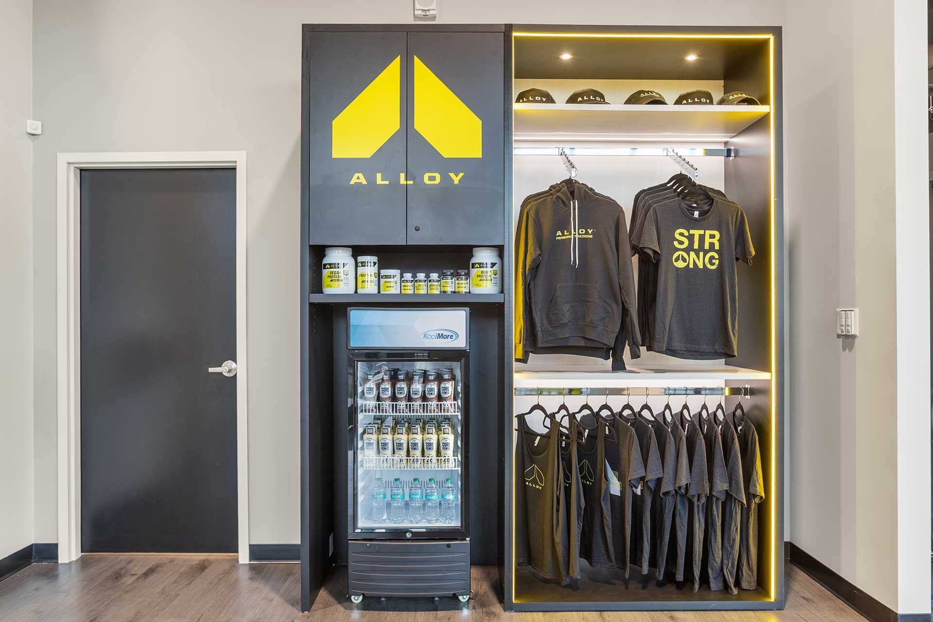 Black Alloy retail display with merchandise, snacks, and refrigerator; yellow logo and accents