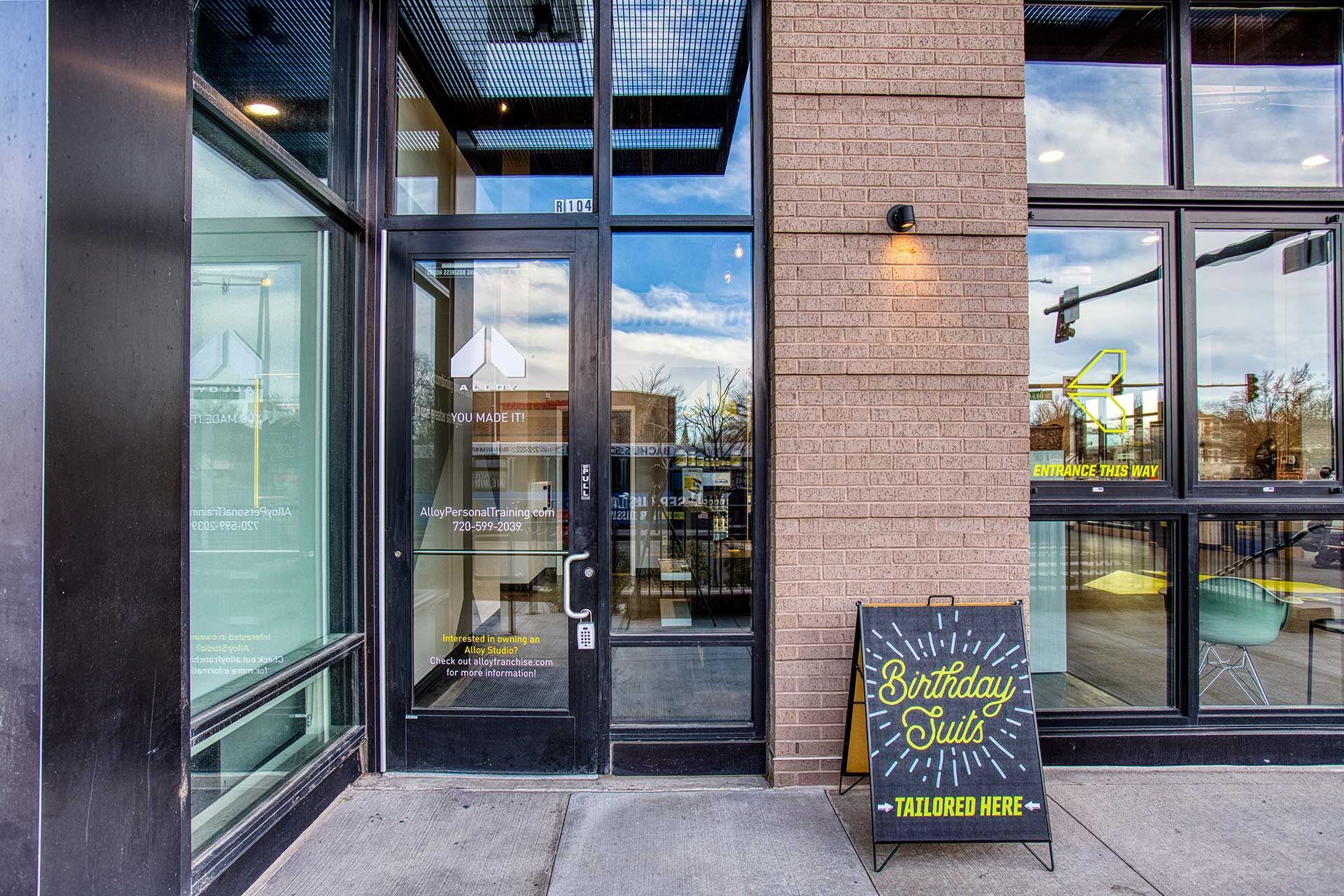 entrance to a gym, glass door and windows, brick and black frame