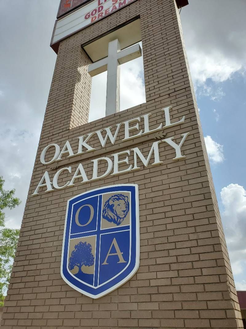A brick tower with the words oakwell academy on it