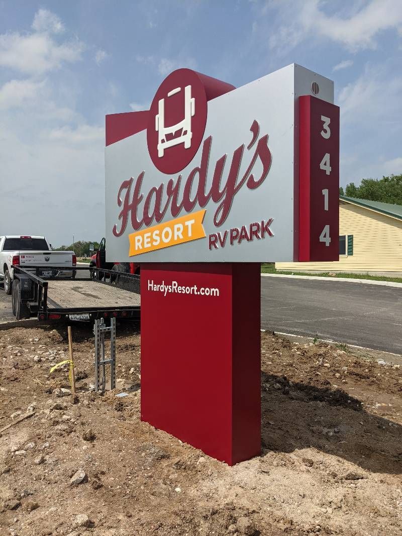 A large red and white sign for hardy 's resort rv park