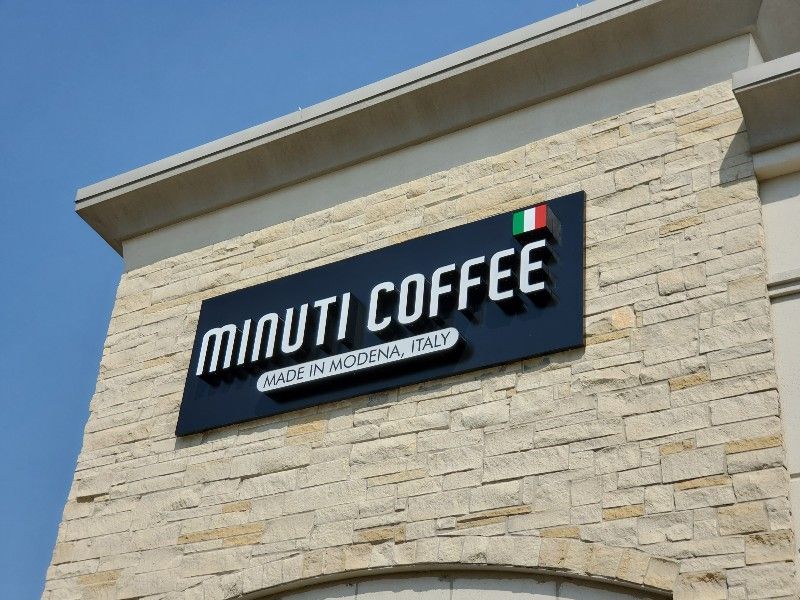 A minute coffee sign is on the side of a building