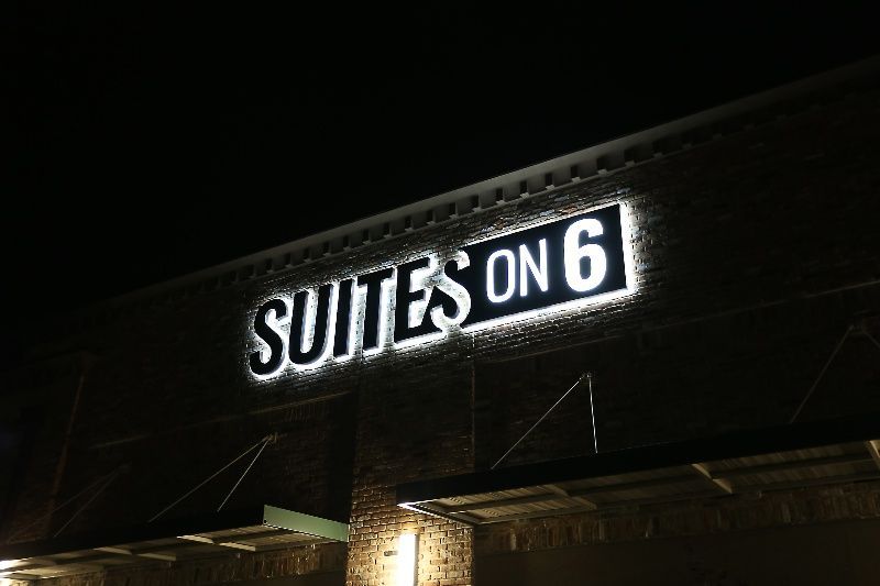 A sign for suites on 6 is lit up at night