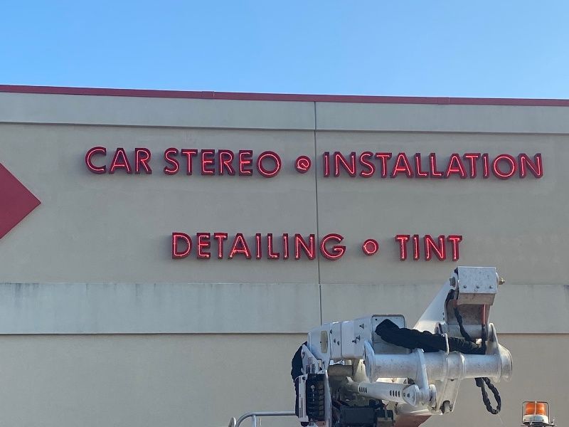A sign on the side of a building says car stereo installation detailing tint