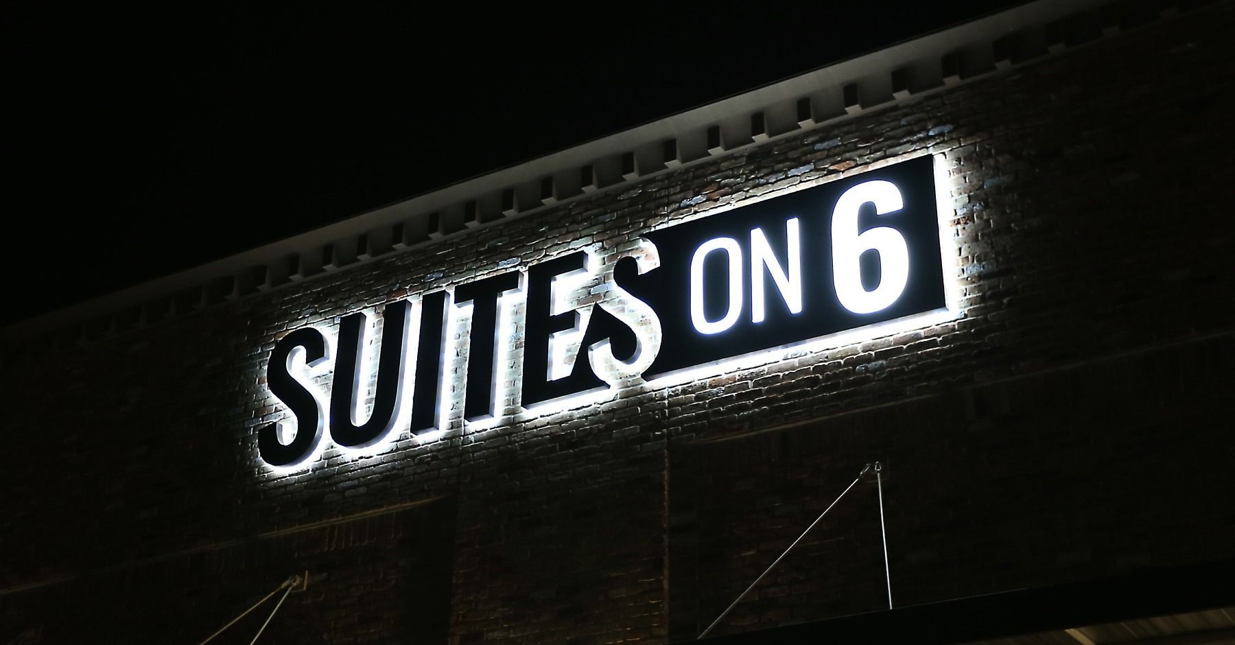 A sign on the side of a building that says suites on 6