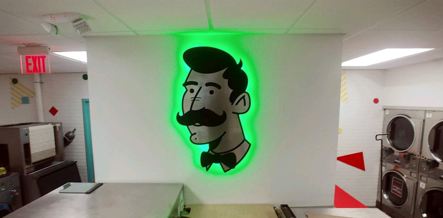 A cartoon of a man with a mustache and bow tie is lit up in a laundromat.
