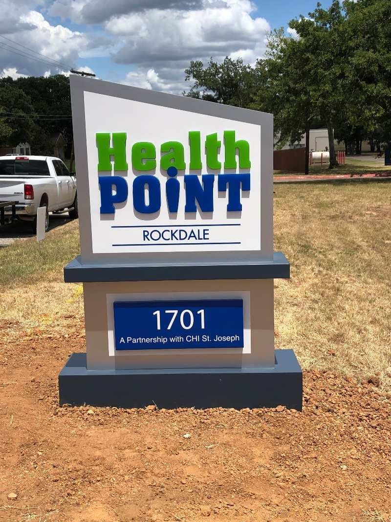 A health point sign is sitting in the middle of a dirt field.