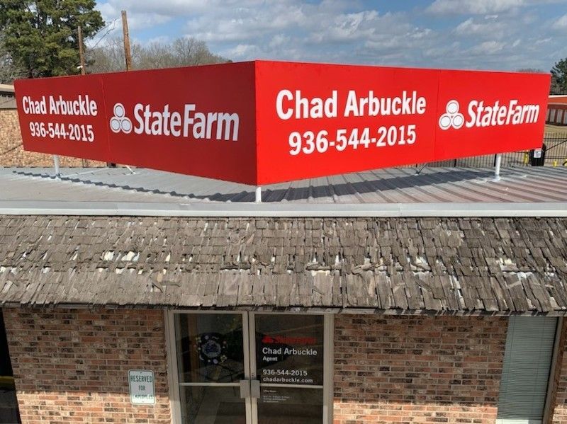 A red sign for state farm is above a brick building