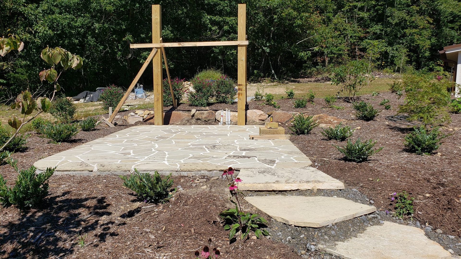 A wooden fence is being built in the middle of a garden