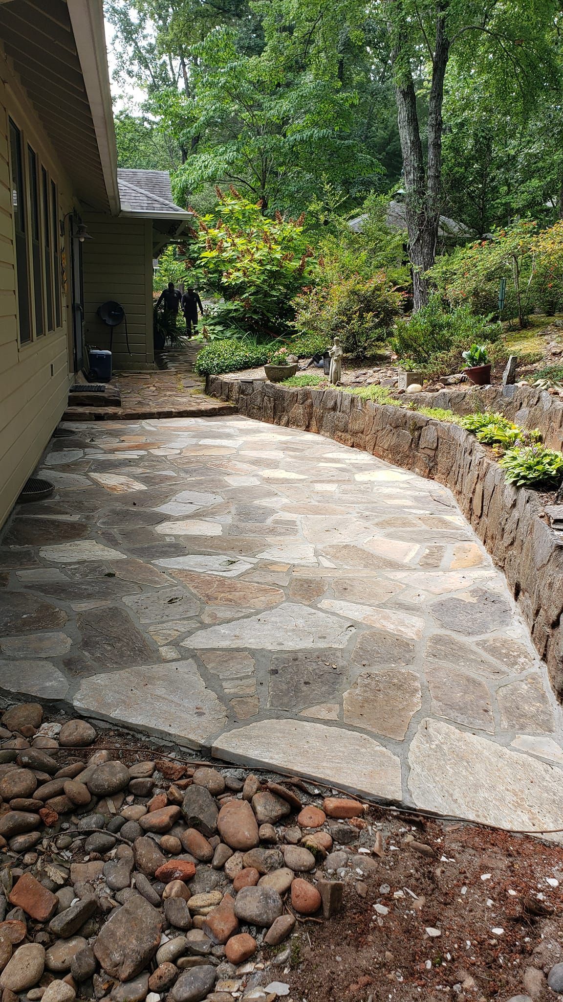 A stone walkway leading to a house in the woods