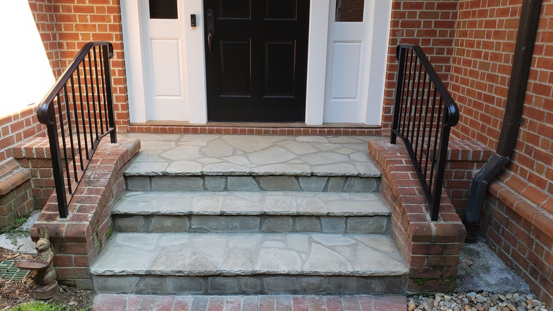 A brick building with stairs leading up to the front door