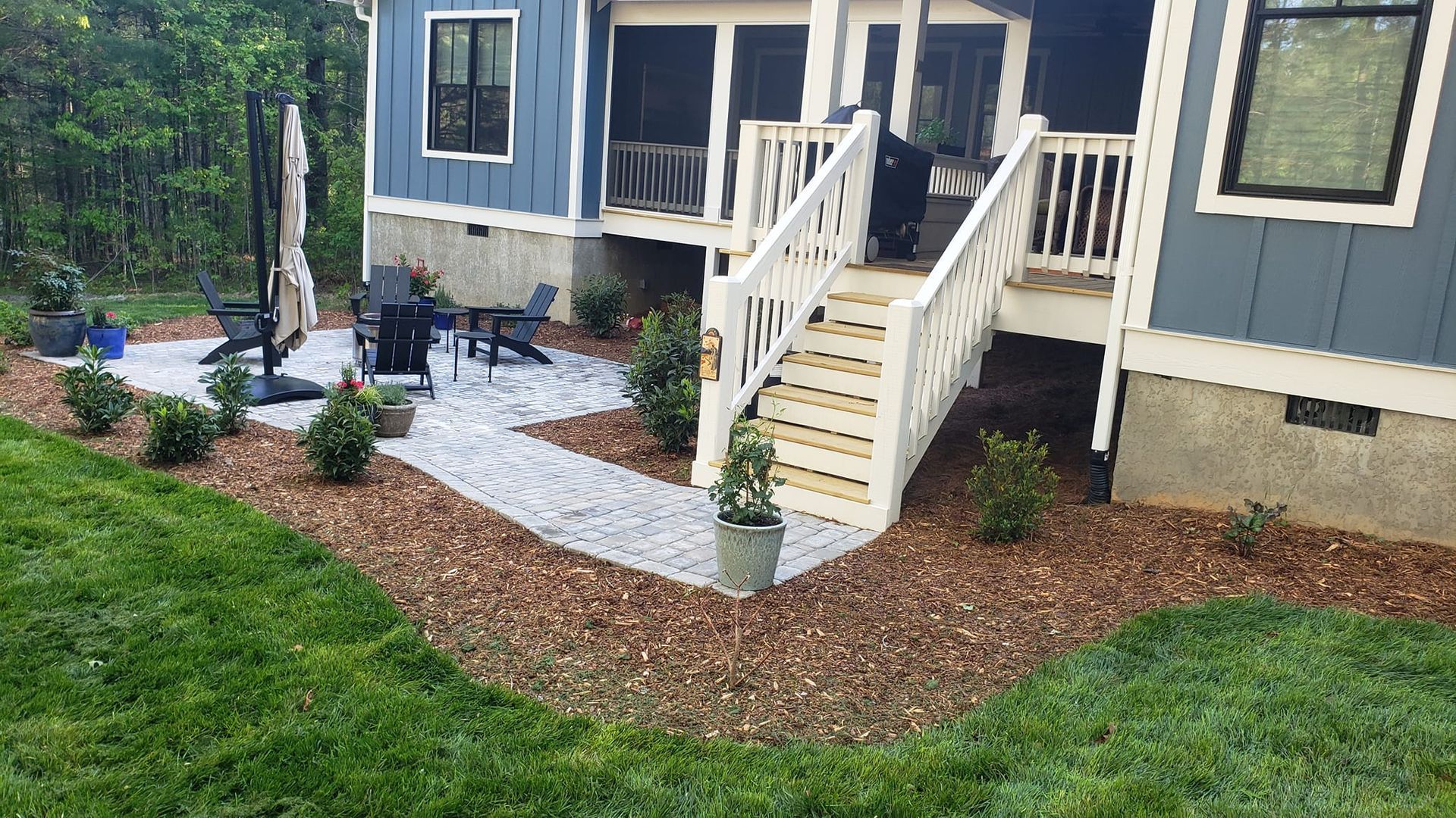 A blue house with a white deck and stairs in the backyard