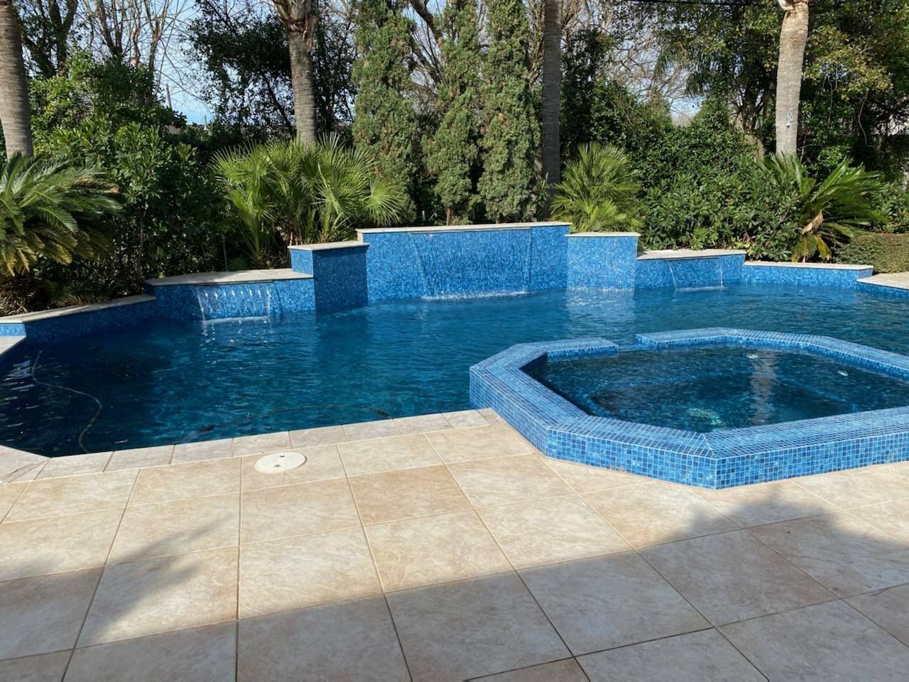 A large swimming pool with a hot tub in the middle