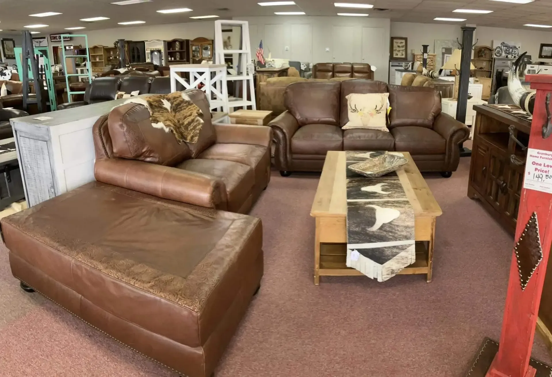 Brown leather sectional sofa and matching couch in a furniture store. A wood coffee table sits in front.