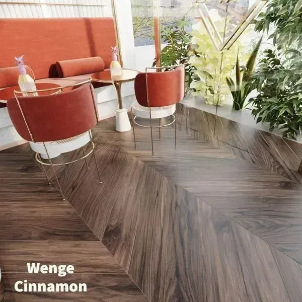 Modern cafe interior with rust-colored velvet booth seating, round bistro tables, and dark wood herringbone flooring.