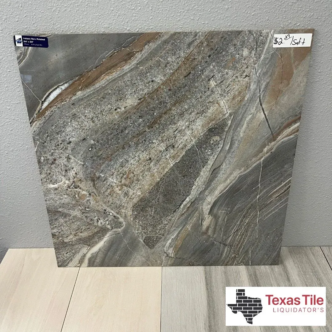 A square, polished tile with a marbled pattern of dark gray, tan, and white veins, displayed at Texas Tile Liquidators.