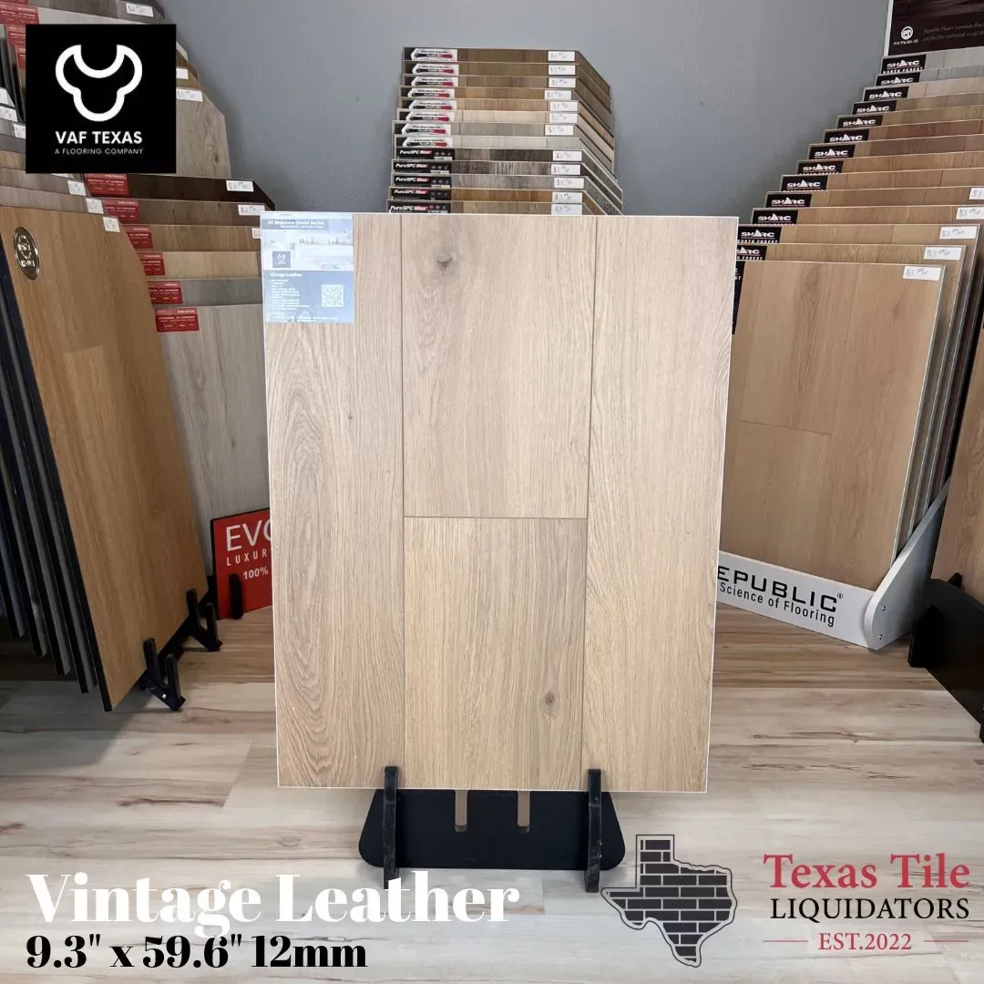 A light wood-grain flooring sample on a display stand at Texas Tile Liquidators, labeled 