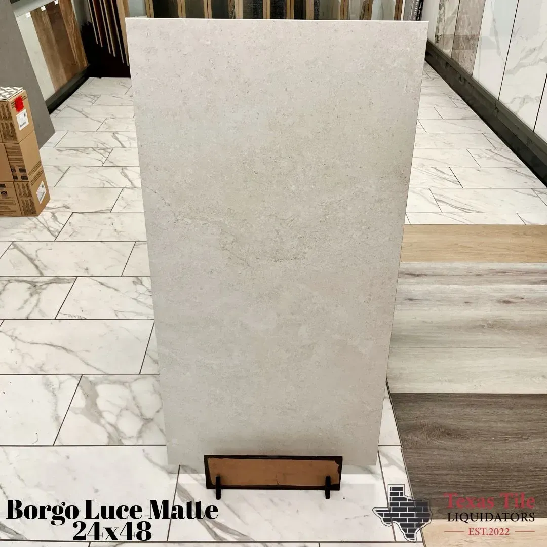 A rectangular Borgo Luce Matte 24x48 tile displayed vertically in a flooring showroom.