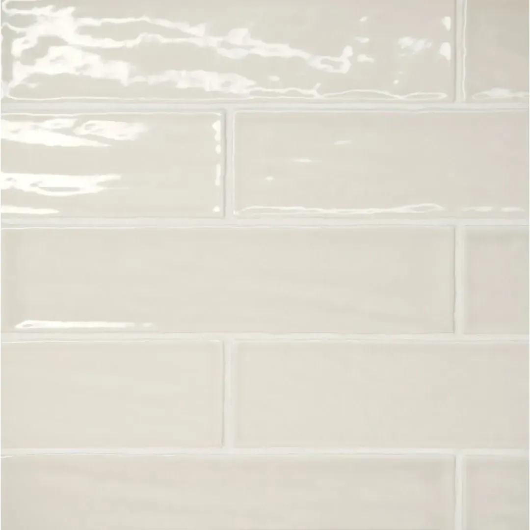 A close-up of glossy, off-white subway tiles arranged in a staggered running bond pattern.