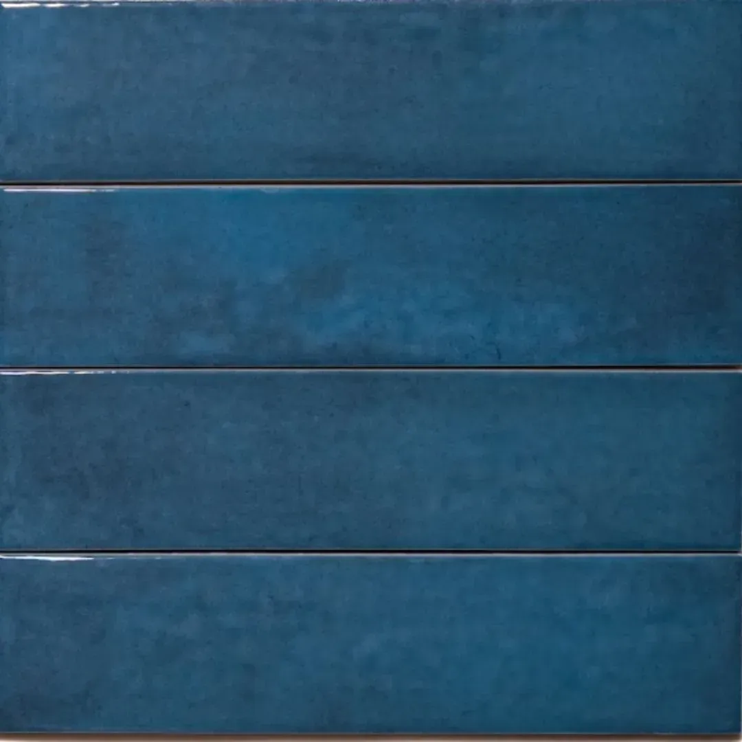 A close-up view of four rectangular, deep blue tiles with a glossy, slightly uneven, hand-crafted texture.