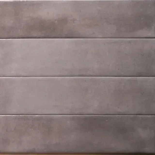 A close-up of a wall made of four horizontal, rectangular, matte grey tiles with a smooth, concrete-like finish.