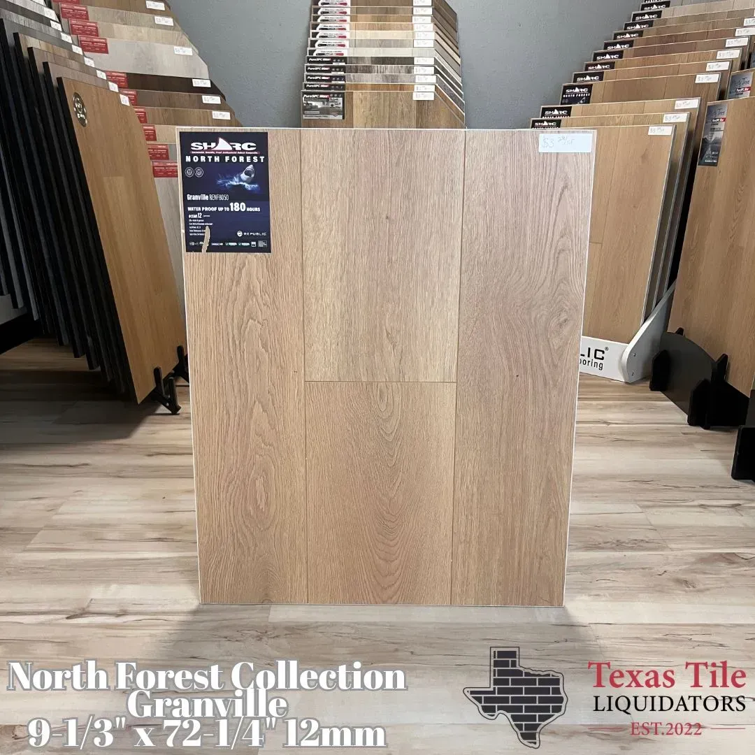 A display board of light oak-colored laminate flooring planks in a Texas Tile Liquidators showroom.