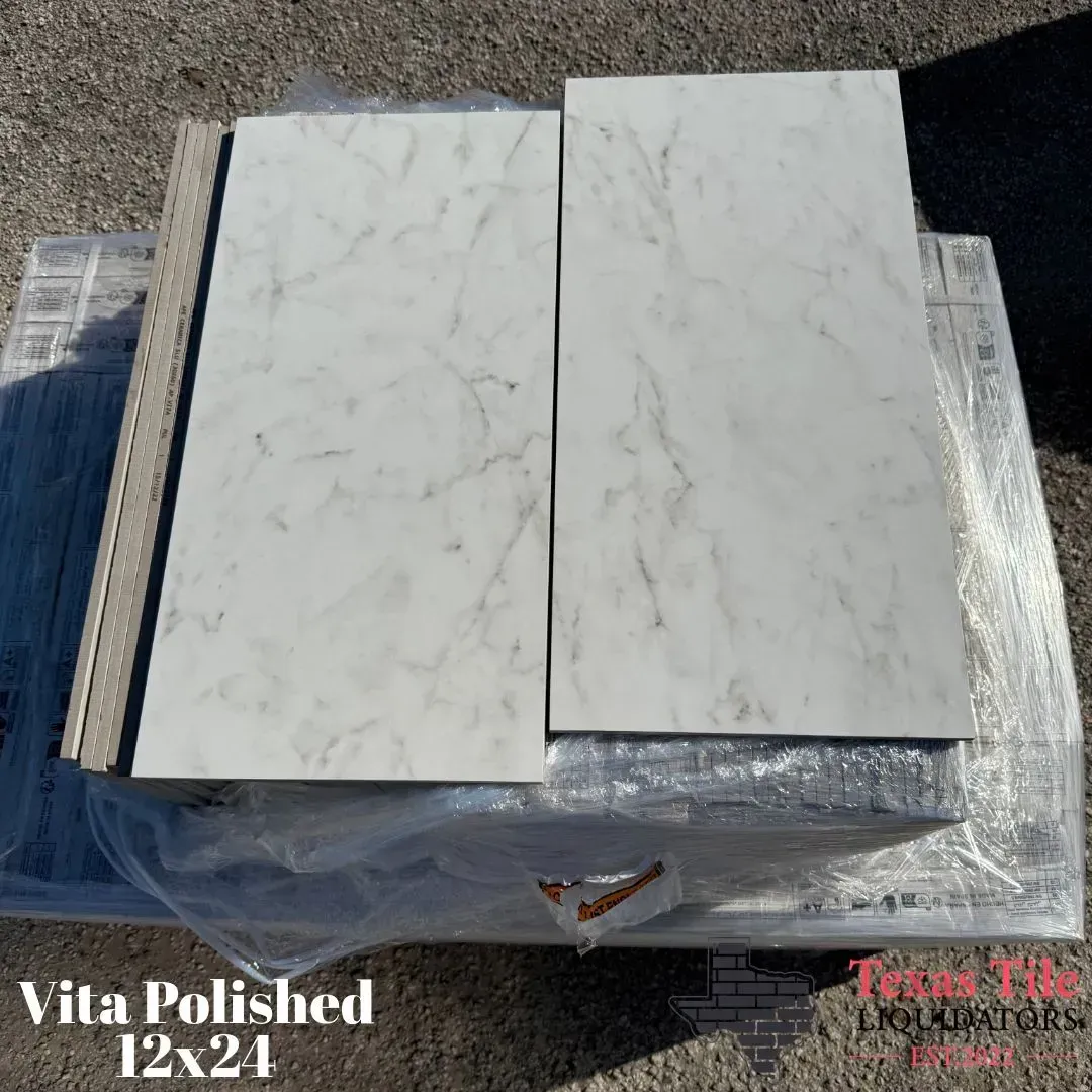 Two white, marble-look 12x24 tiles with grey veining displayed on a pallet.