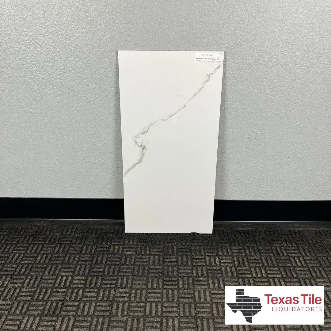 A large white rectangular porcelain tile with a thin, jagged marble-style vein, standing against a gray wall.