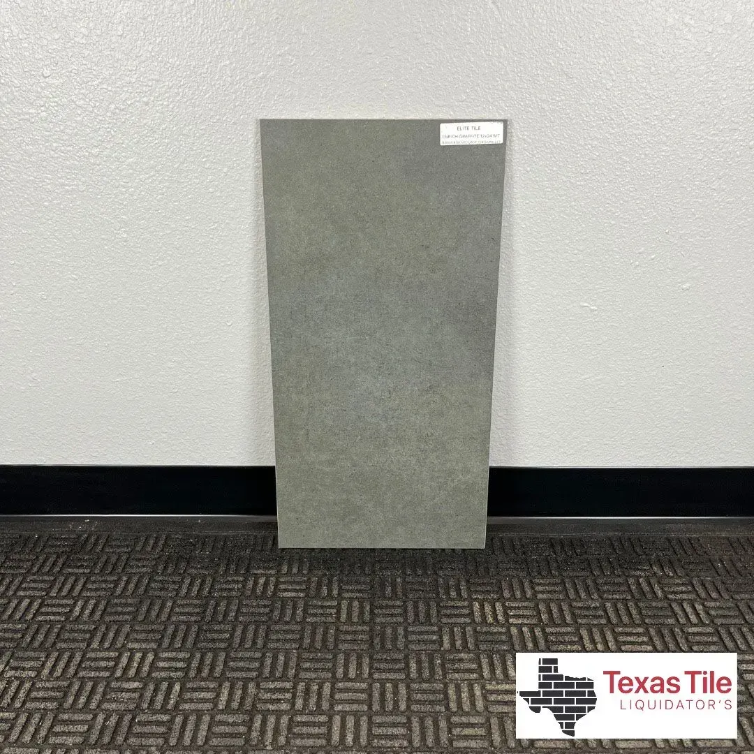 A single rectangular, gray, textured tile stands upright against a plain wall, with a Texas Tile logo in the corner.