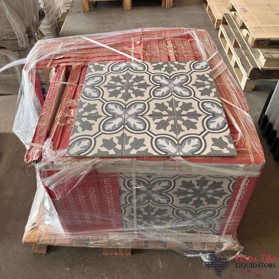 A pallet of square, decorative floor tiles featuring a gray and white floral pattern, wrapped in clear plastic.