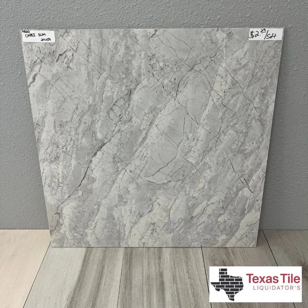 A square grey marble-look floor tile sample with veining patterns sits above flooring planks with a Texas Tile logo below.