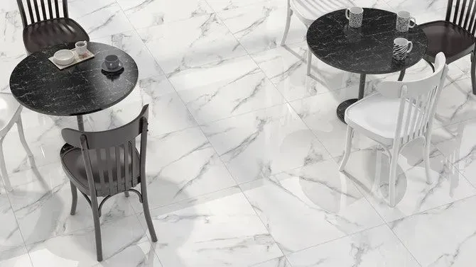 Two round black tables with chairs sit on a white marble-patterned tile floor.