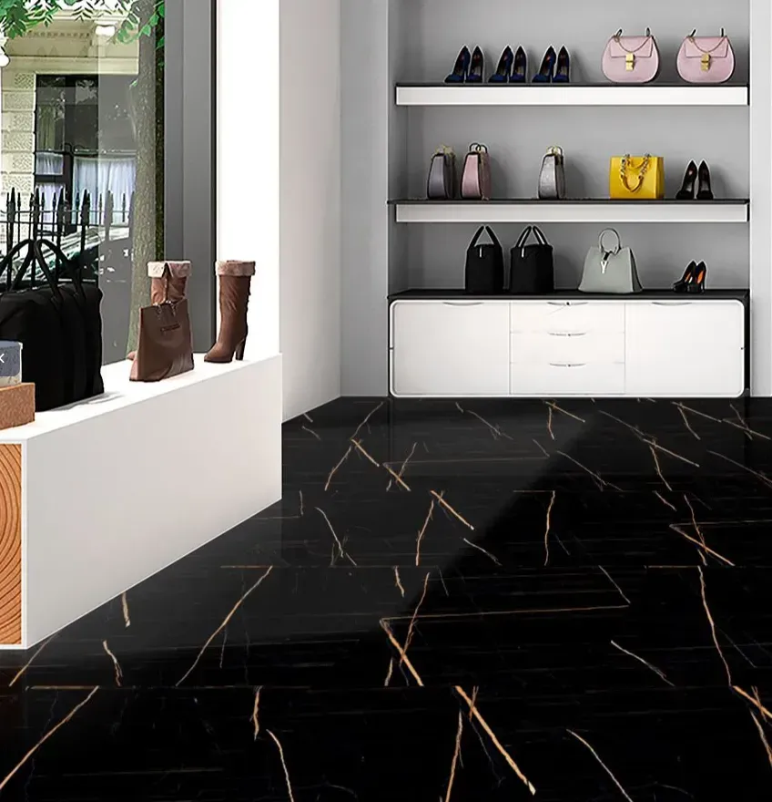 A luxury boutique display with black marble floors, featuring shelves of handbags and shoes, and brown leather boots.