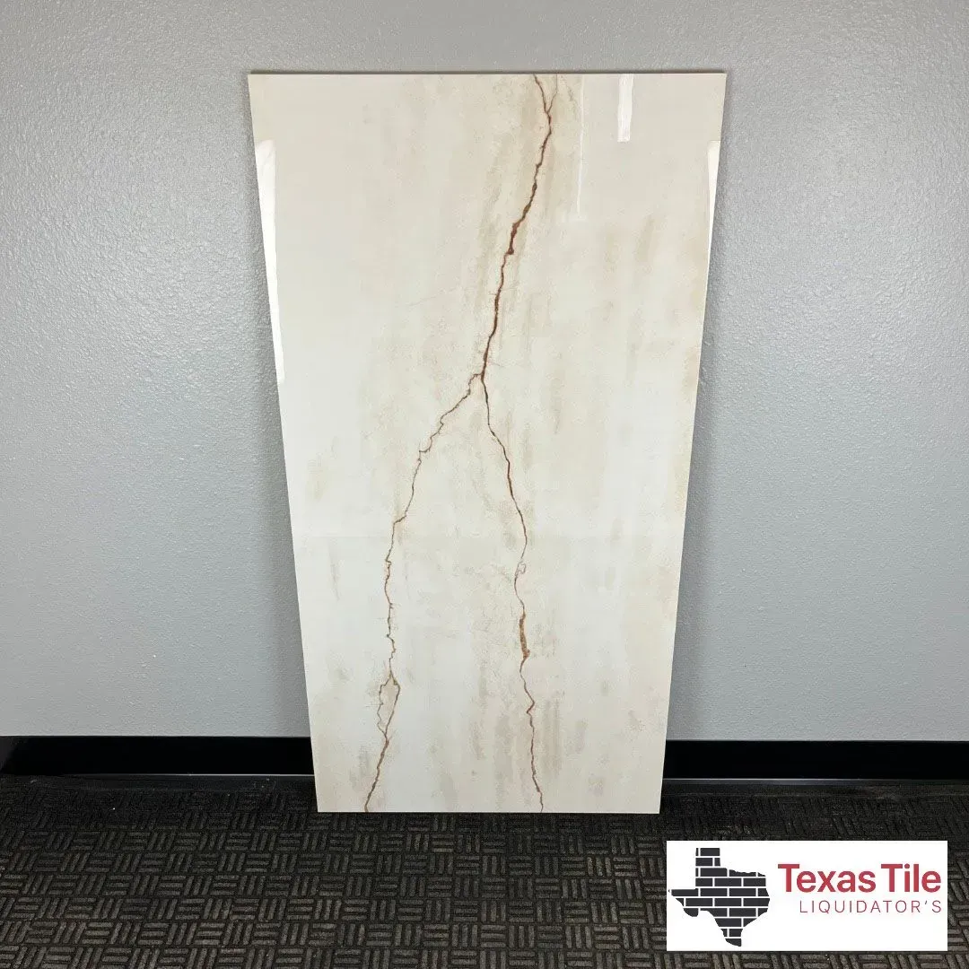 A rectangular, cream-colored tile with a prominent brown vein running down its center, displayed against a gray wall.