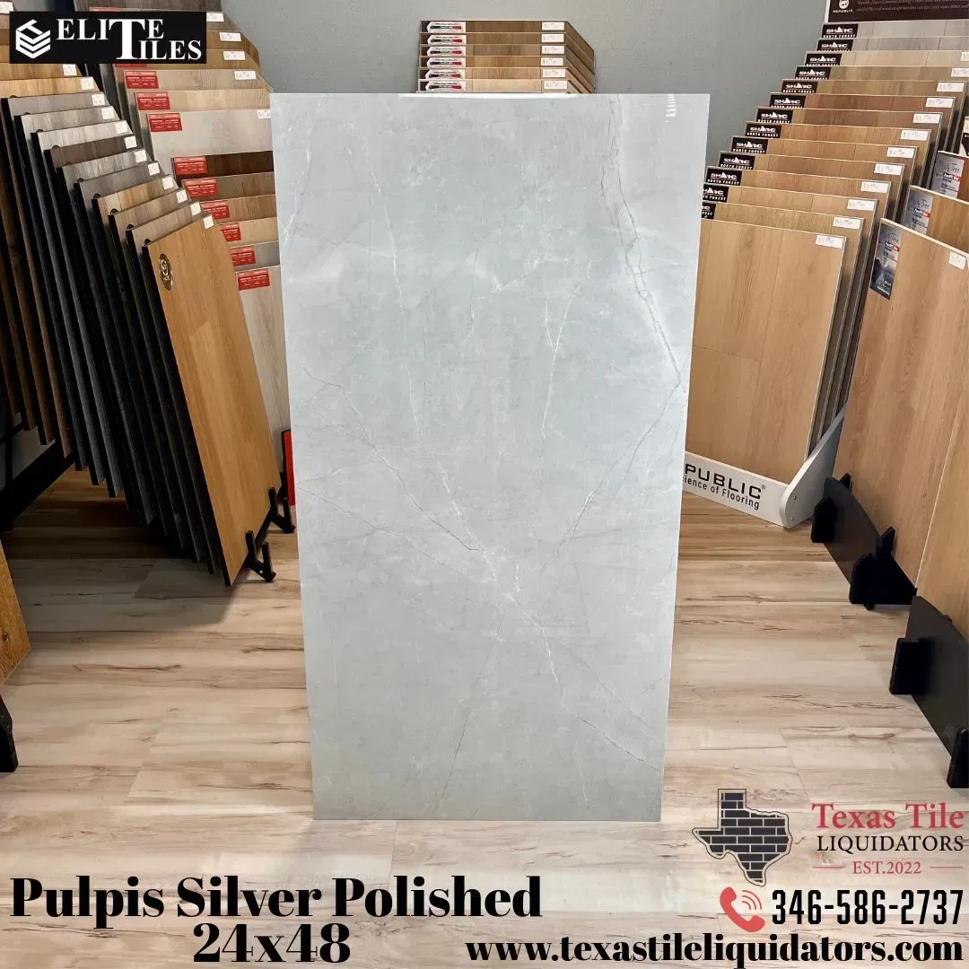A vertical, rectangular, polished silver marble tile on display in a tile showroom.