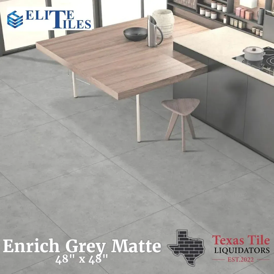 A modern kitchen scene showcasing large, matte grey floor tiles measuring 48 by 48 inches with wooden table and accents.