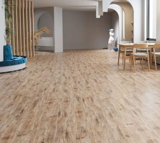 A bright, modern interior space with light-toned wood-look tiled flooring, arched architectural details, and a dining area.