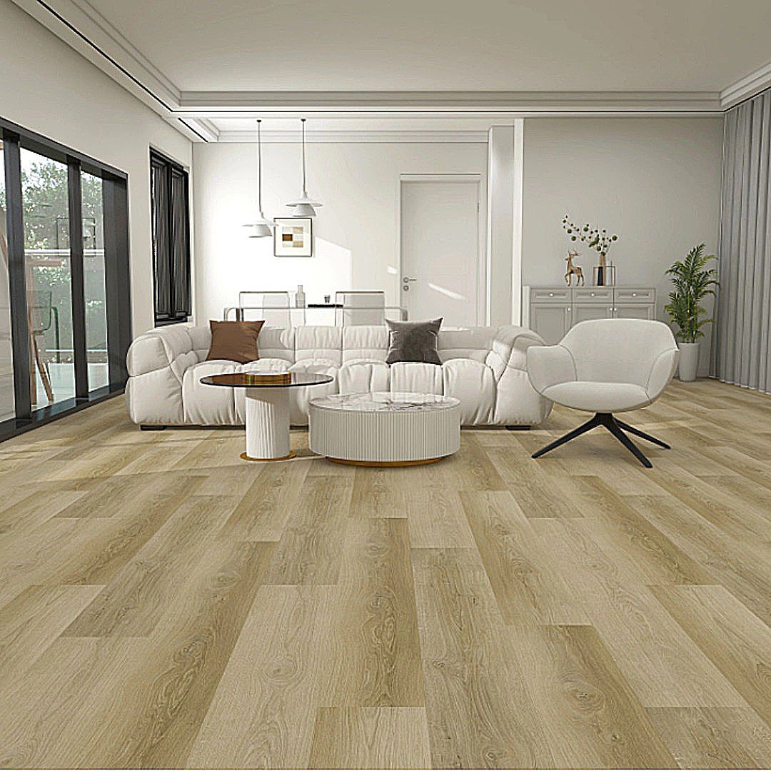 A bright, modern living room featuring wood flooring, a white sofa with dark pillows, a white ottoman, and an armchair.