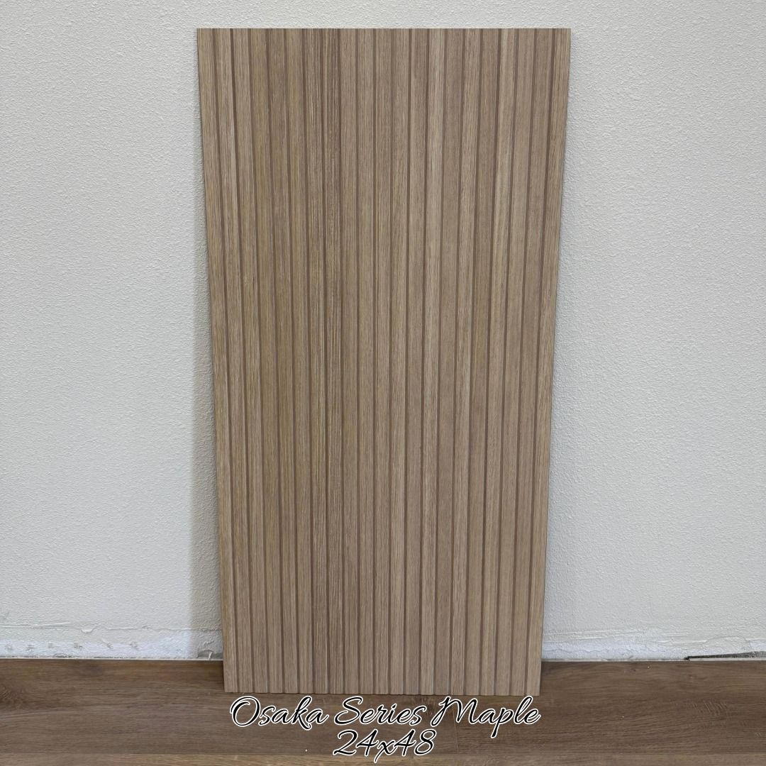 A rectangular, light-brown wood-look wall panel with a vertical slatted texture, standing upright against a white wall.