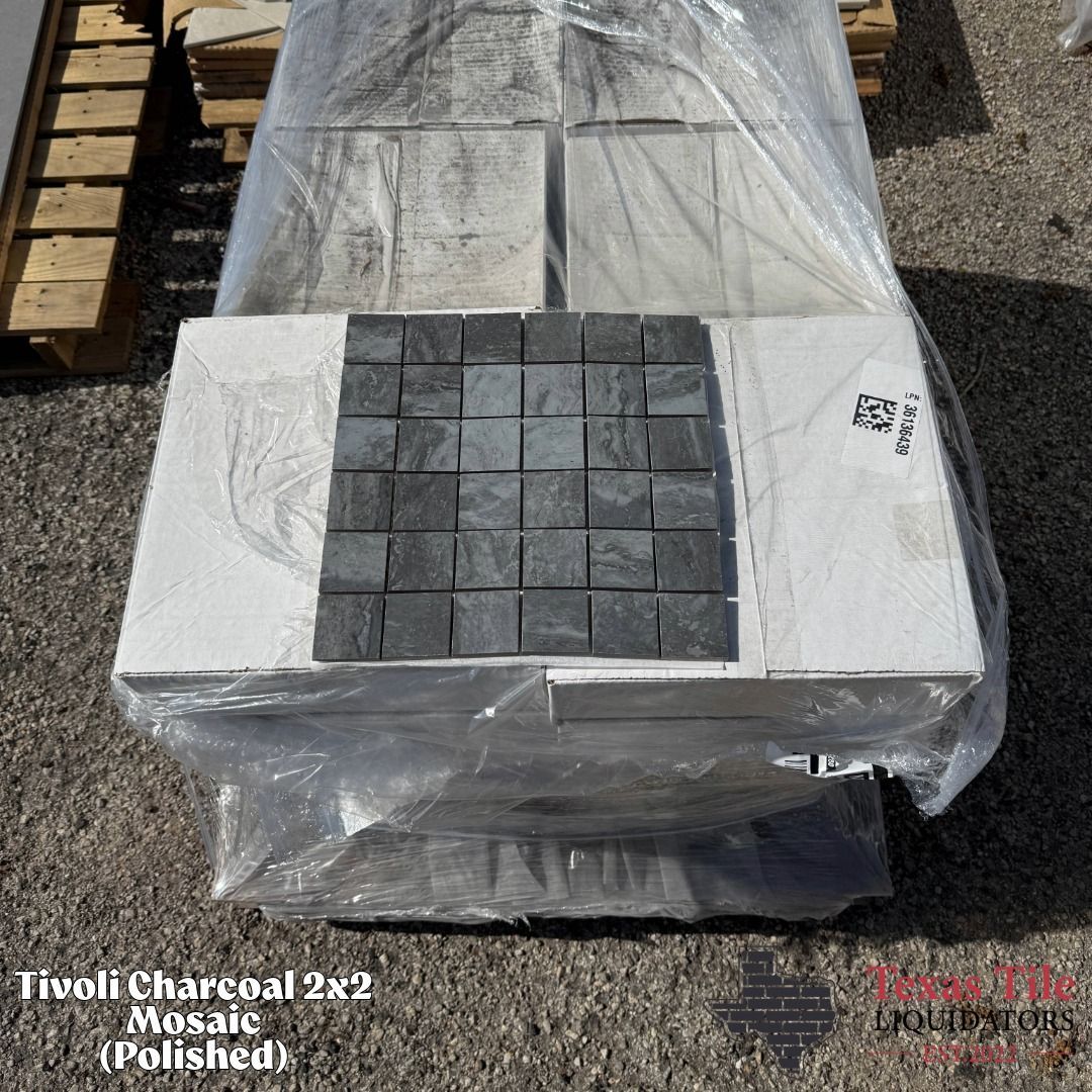 A stack of Tivoli Charcoal 2x2 polished mosaic tiles wrapped in plastic on a pallet.