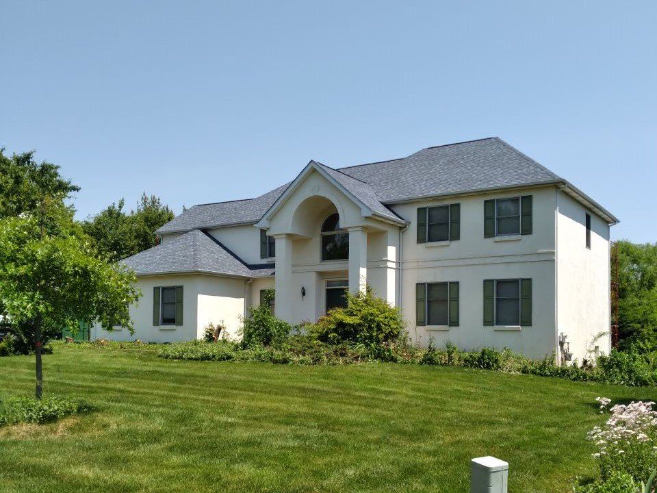 A large white house with a gray roof