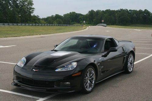 Black sports car on a race track under an overcast sky