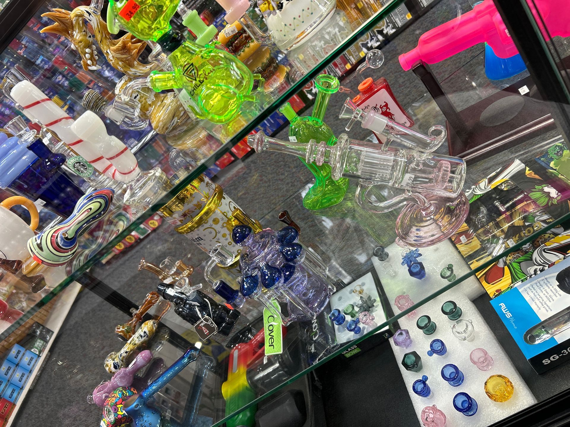 Glass pipes and bongs for sale in a display case.