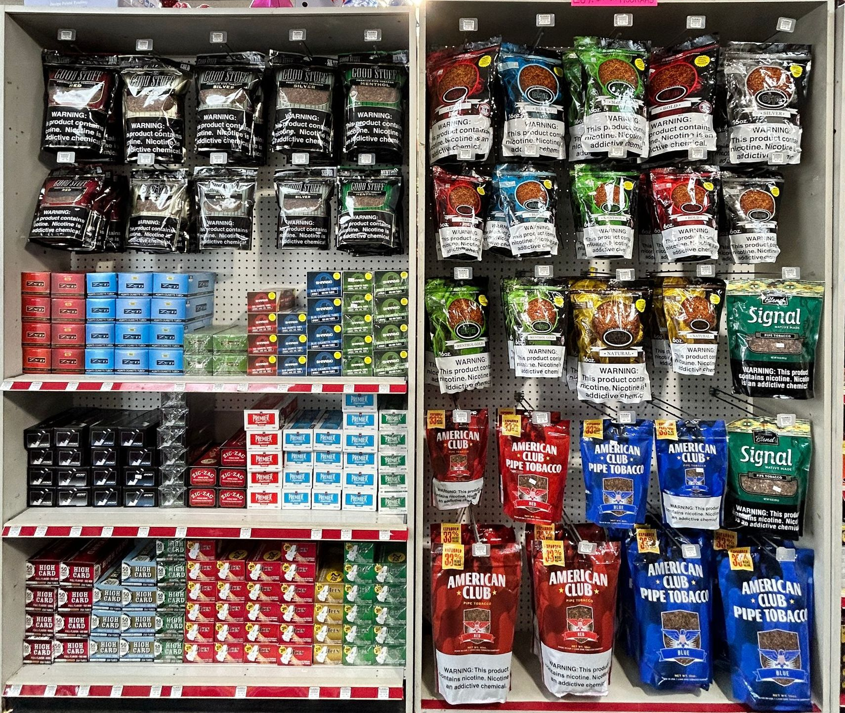 Shelves stocked with tobacco products, including pouches and tins, in a retail setting.