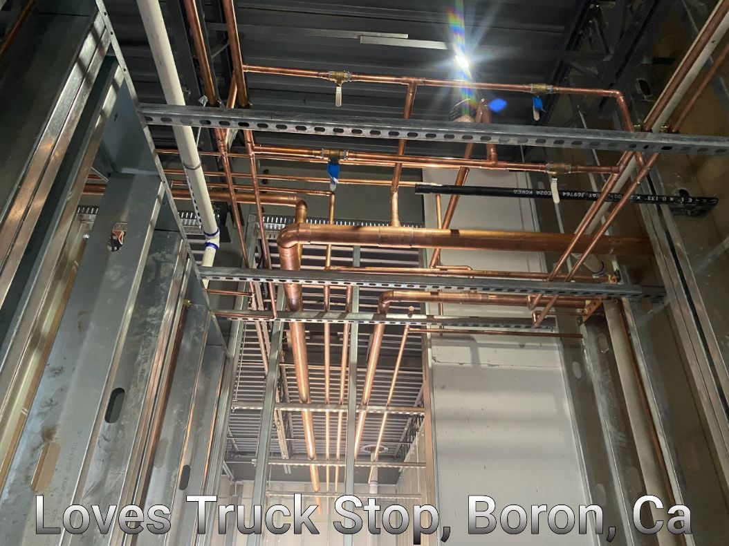 Copper pipes are hanging from the ceiling of a building