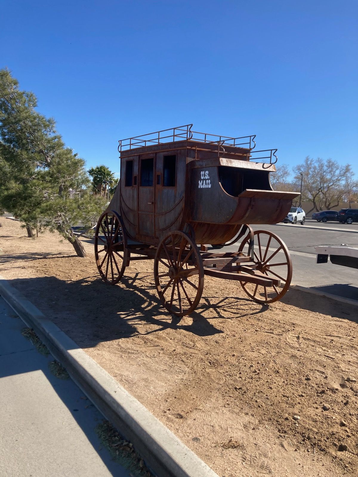 A horse drawn carriage is parked on the side of the road.