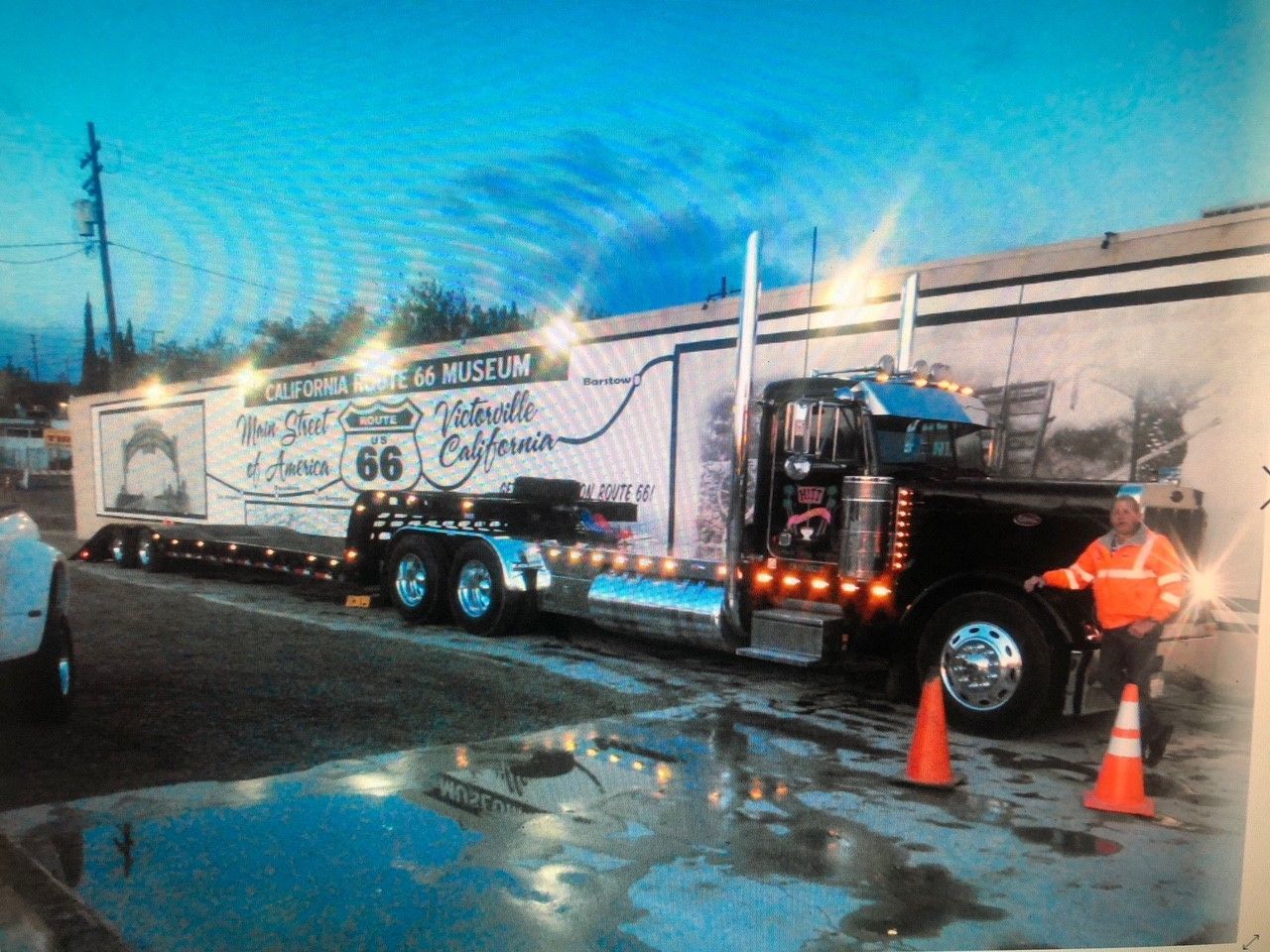 A man standing next to a truck that says route 66 on it.