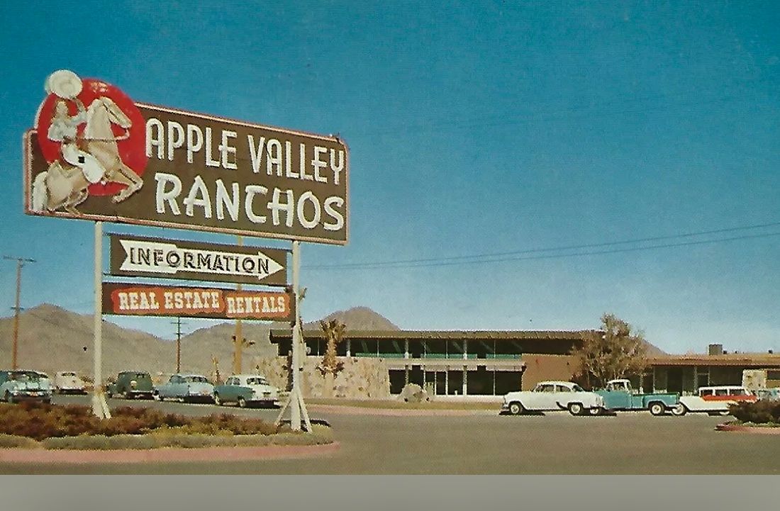 A sign for apple valley ranchos is in front of a building.