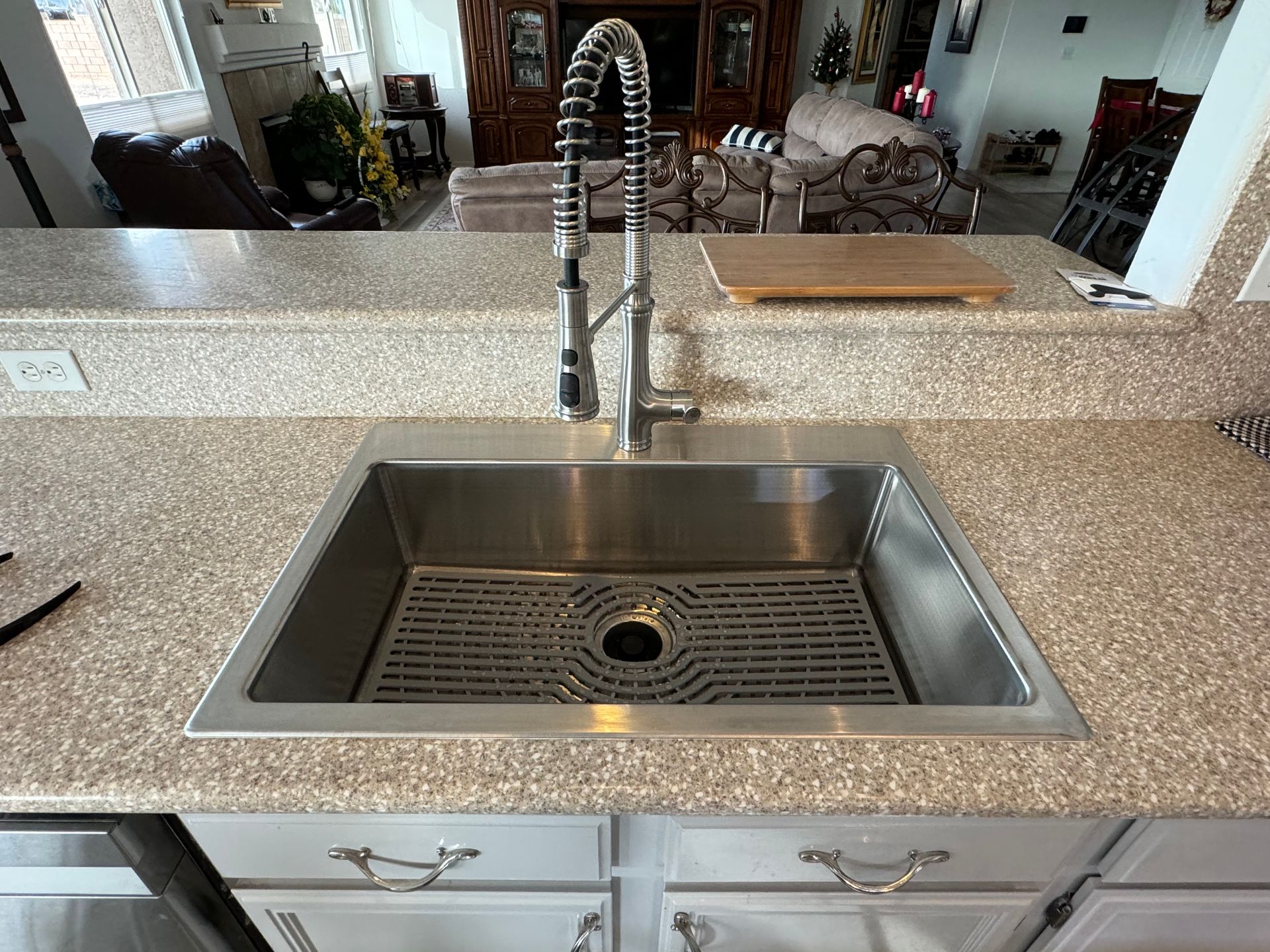 A kitchen sink with a stainless steel faucet and granite counter tops.